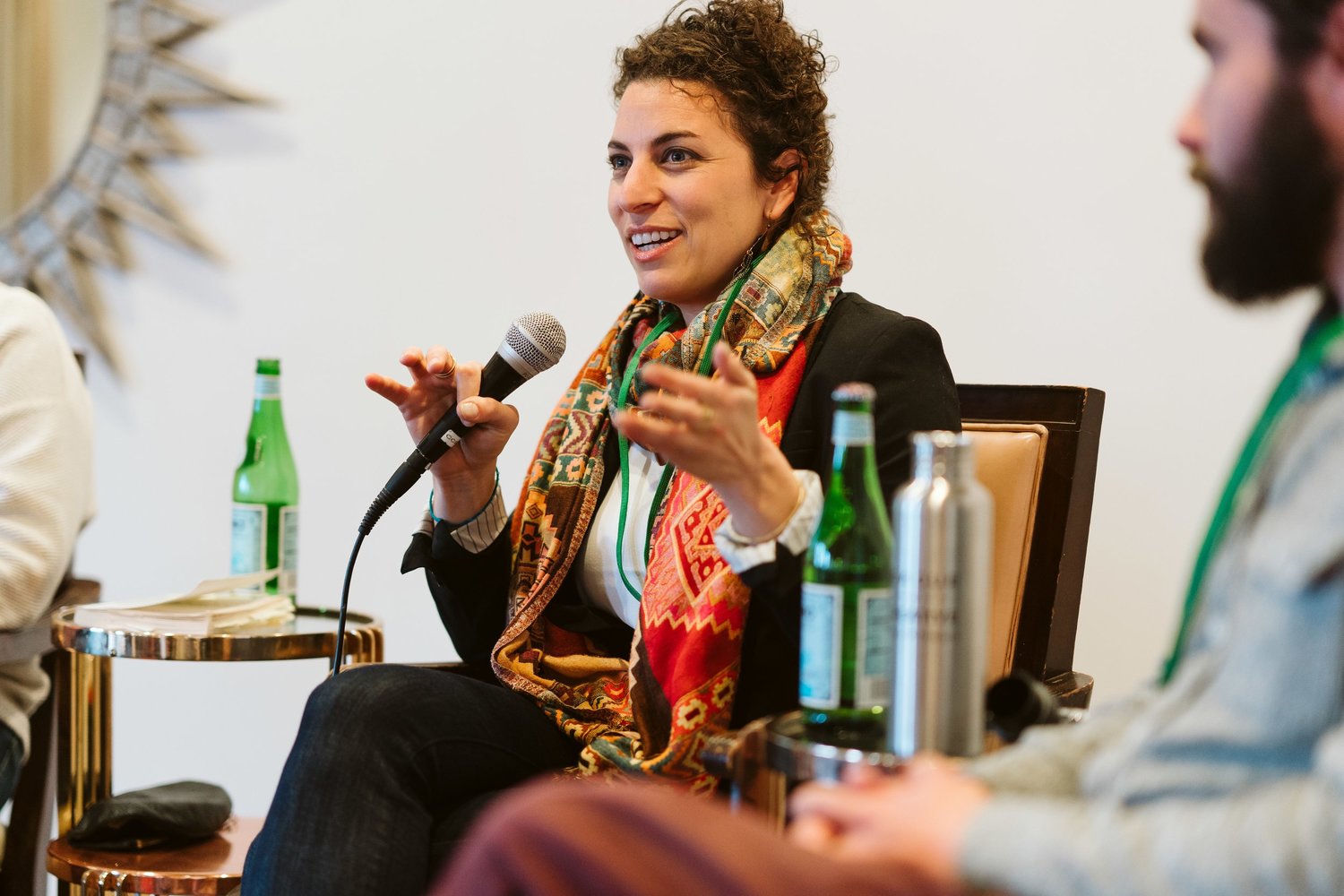 Ilana Lipsett speaking animatedly into a microphone while sitting.